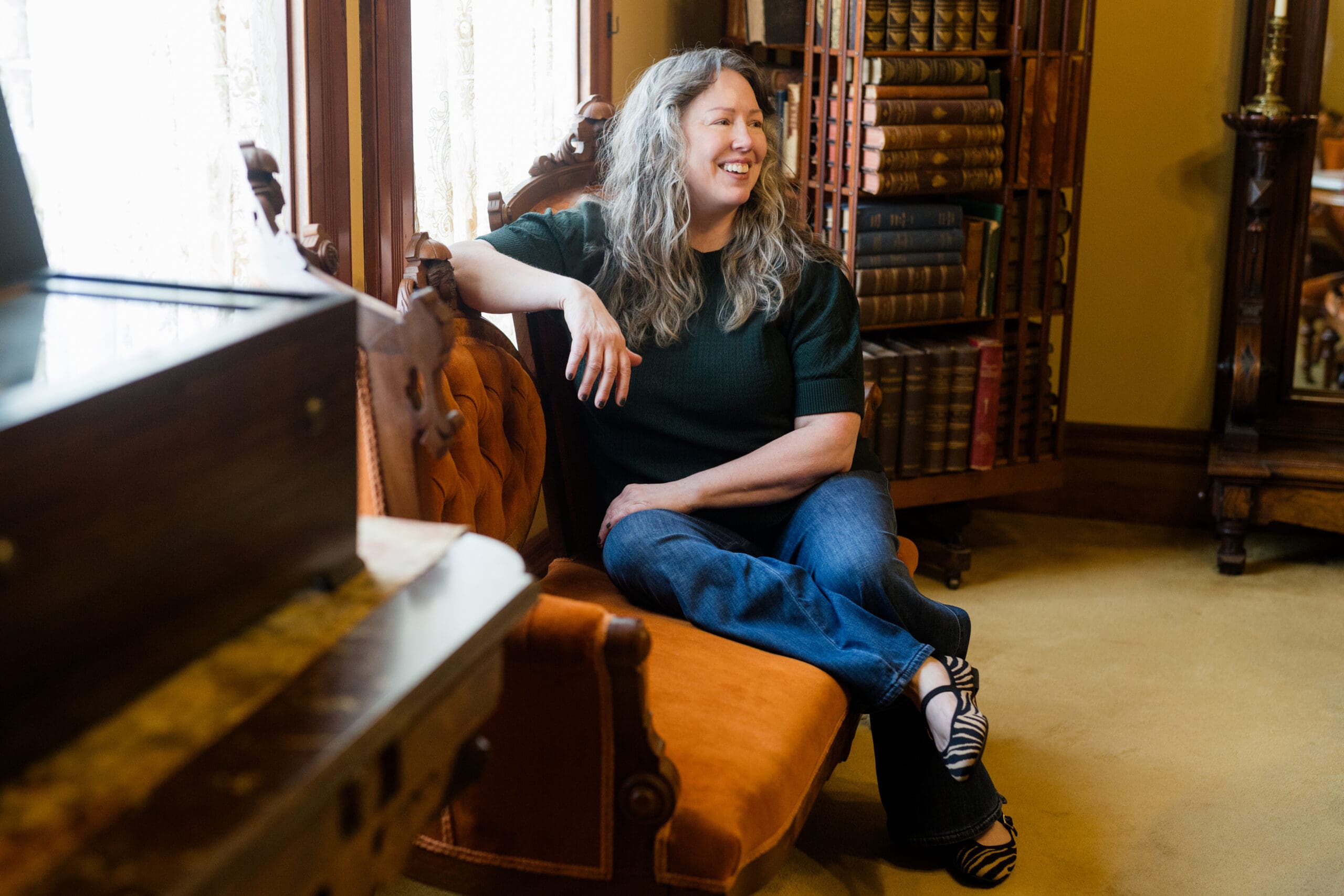 Jacqueline Renee sitting on a vintage couch.